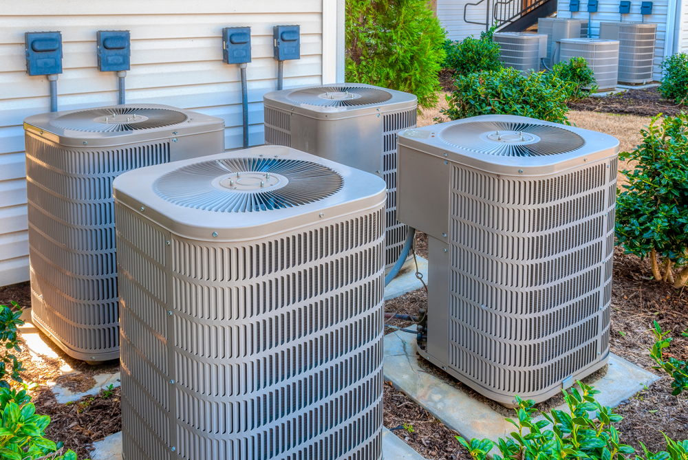 A group of four outdoor air conditioner units.