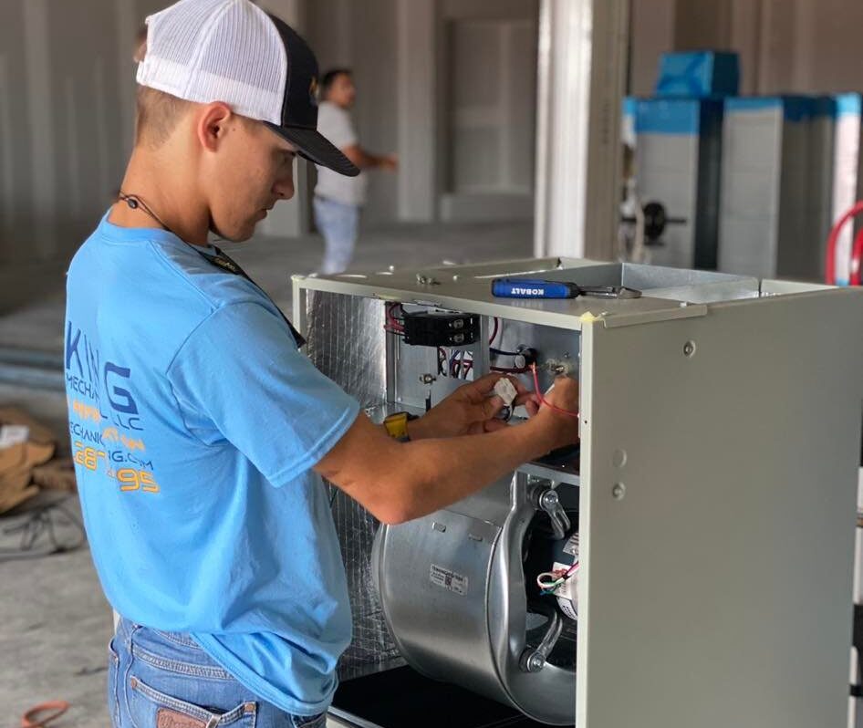A King Mechanical team member performs service on HVAC equipment.