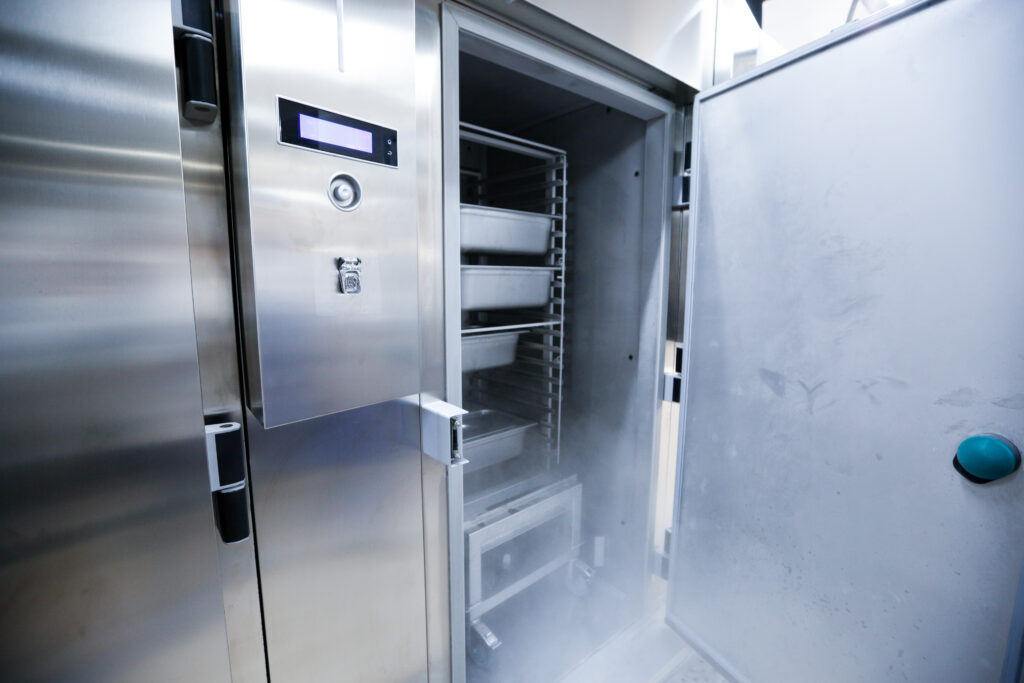 A silver, industrial-sized restaurant freezer and refrigerator.