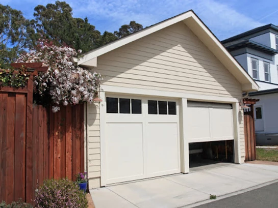 A garage with two doors. One door is halfway open.