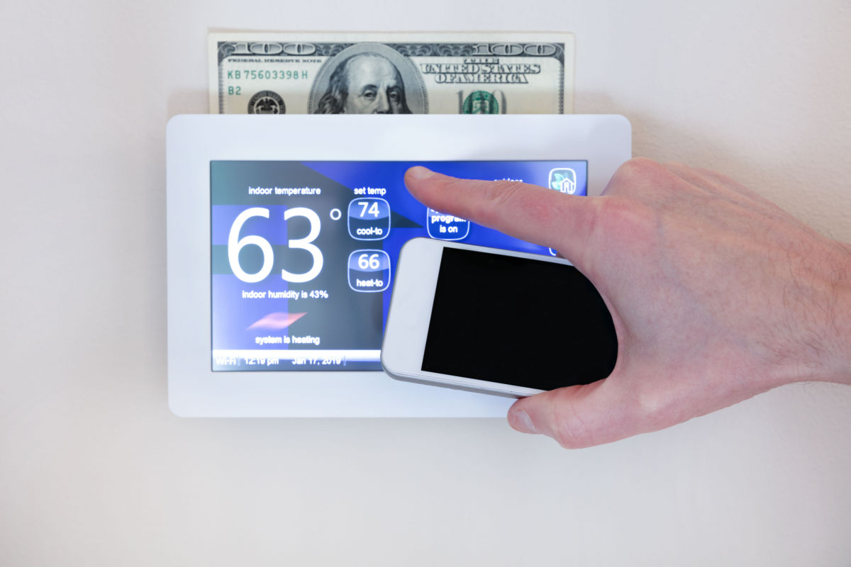 smart thermostat with $100 bill behind it to show the energy savings earned