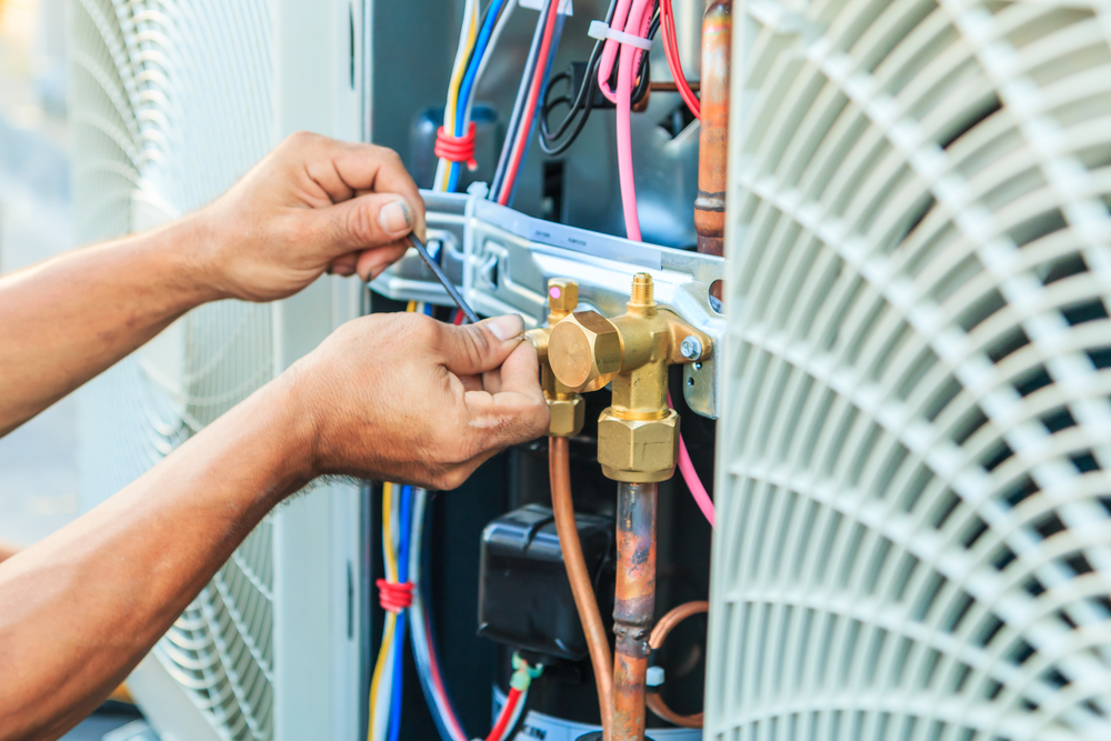 A technician performing air conditioner repair.